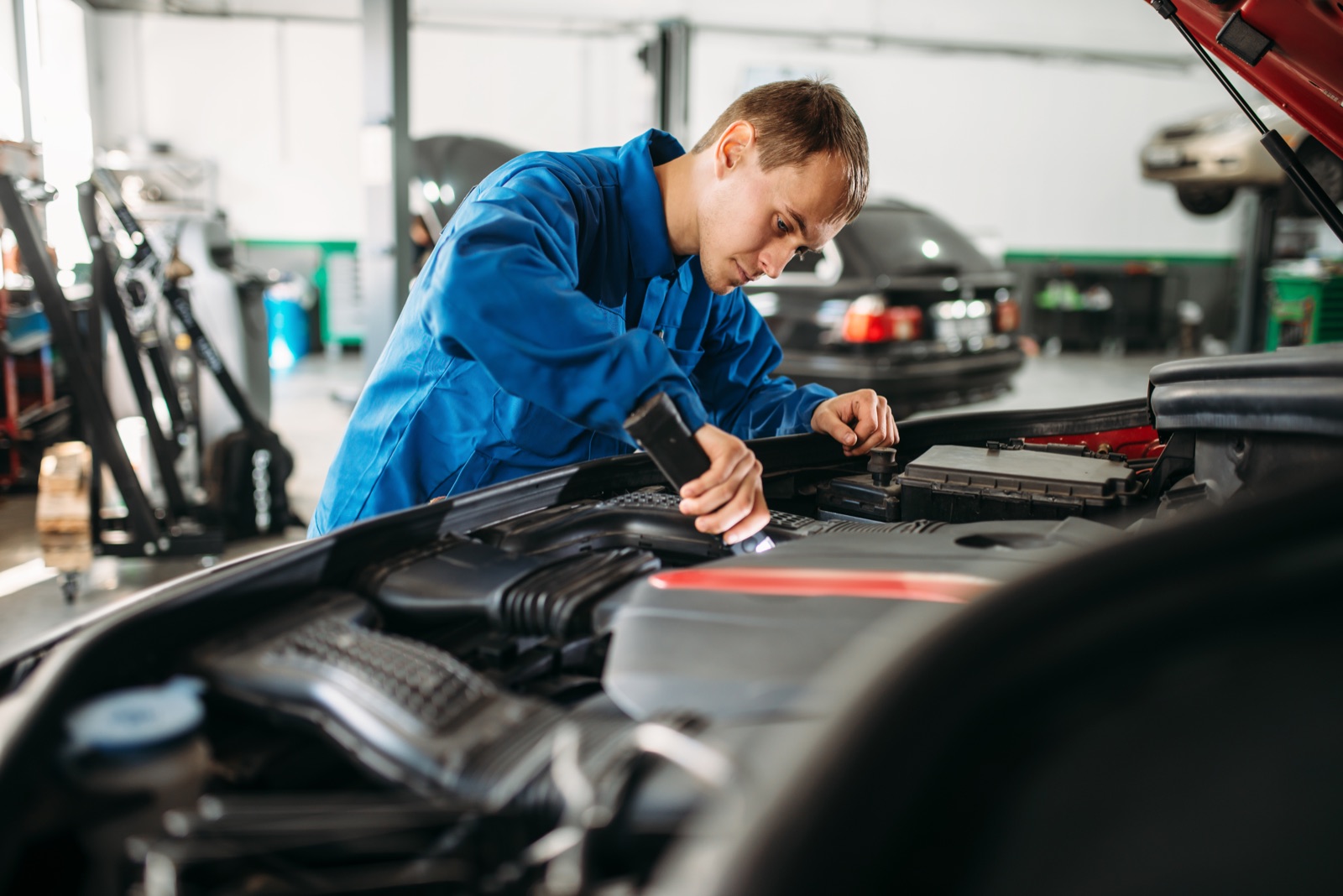 Mechanic working under the bonnet in an Australian workshop